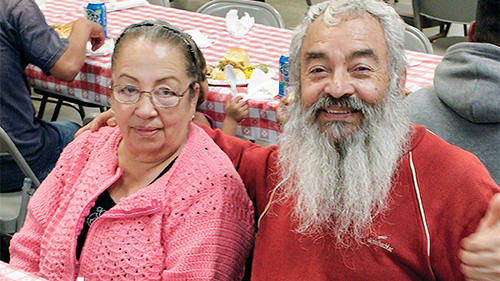 A smiling elderly couple enjoy a meal at Rescue Mission Alliance Central Coast