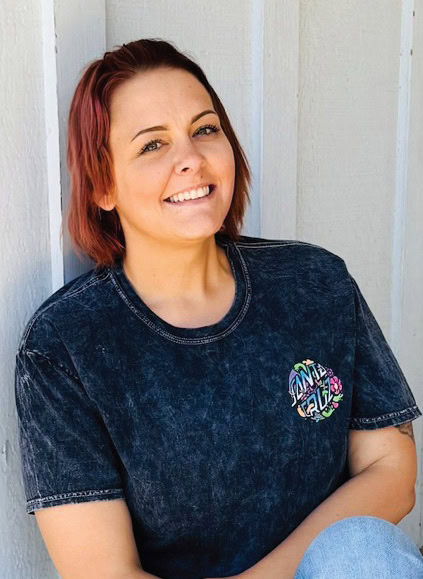 Smiling woman with red hair wearing a Rescue Mission Alliance T-shirt.