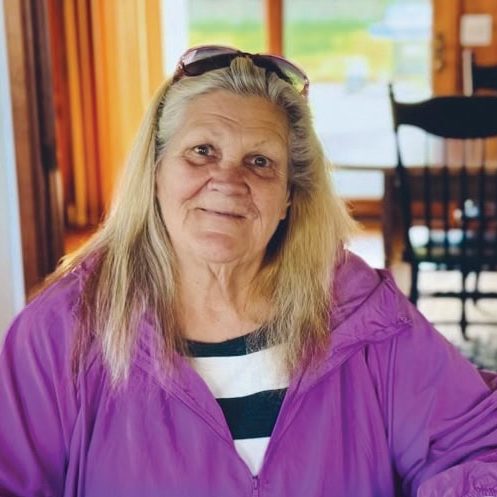 Helping woman at Rescue Mission Alliance Central Coast smiling indoors.