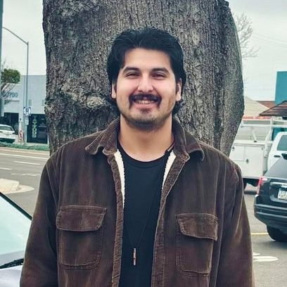 Mike standing against a tree